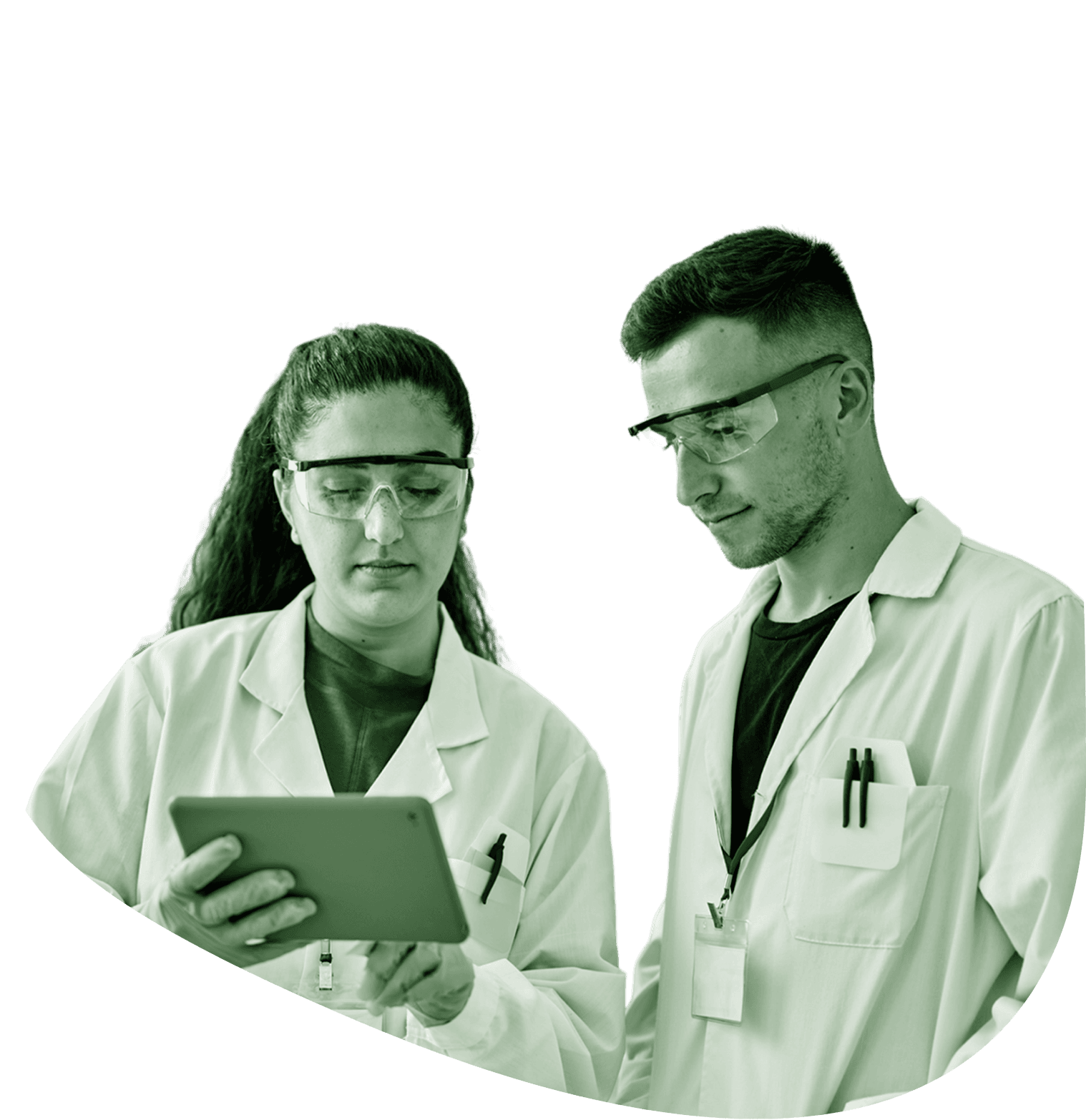 Two women in lab coats and protective eyewear look through a miscroscope